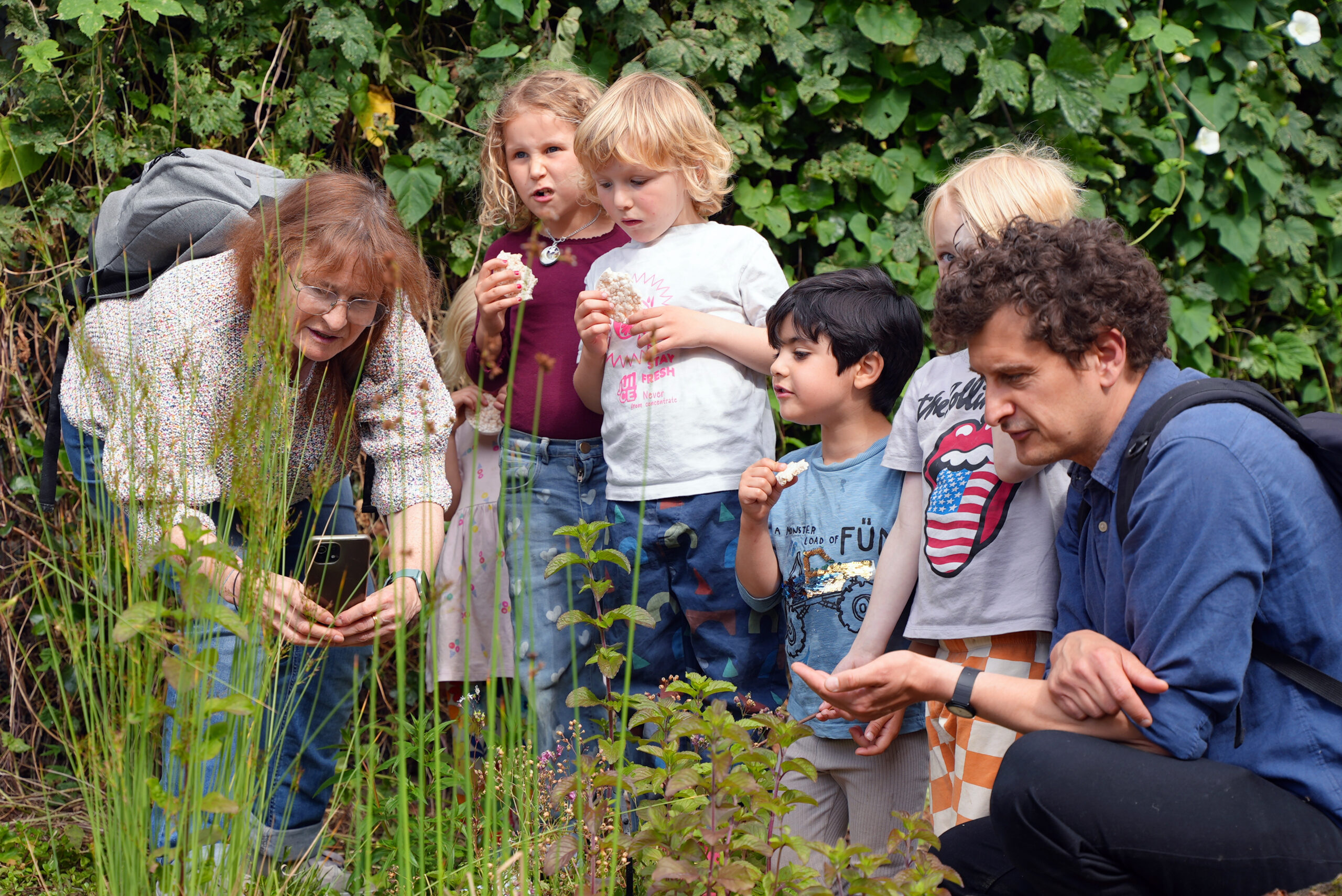 Adults and children observing wildlife by a school pond